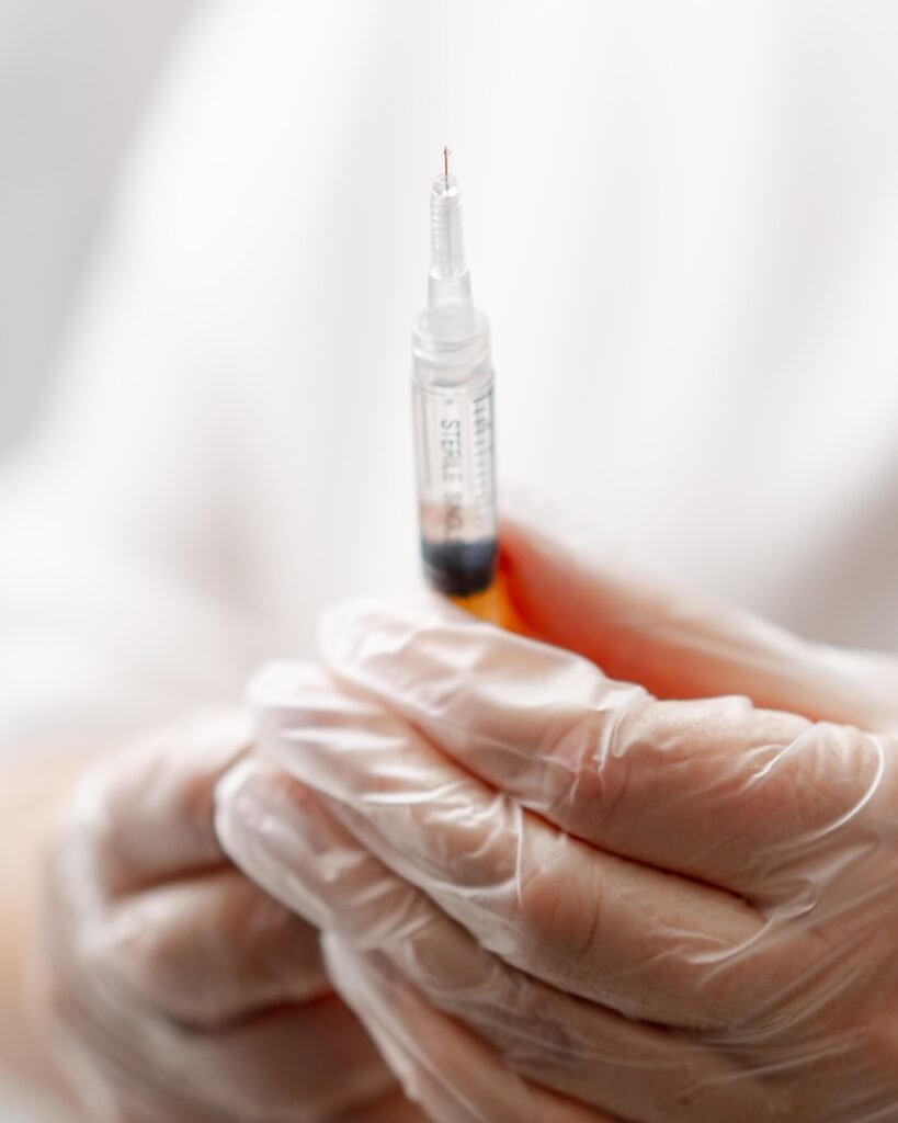 Hands of female doctor hand holding syringe for injection on background medical office